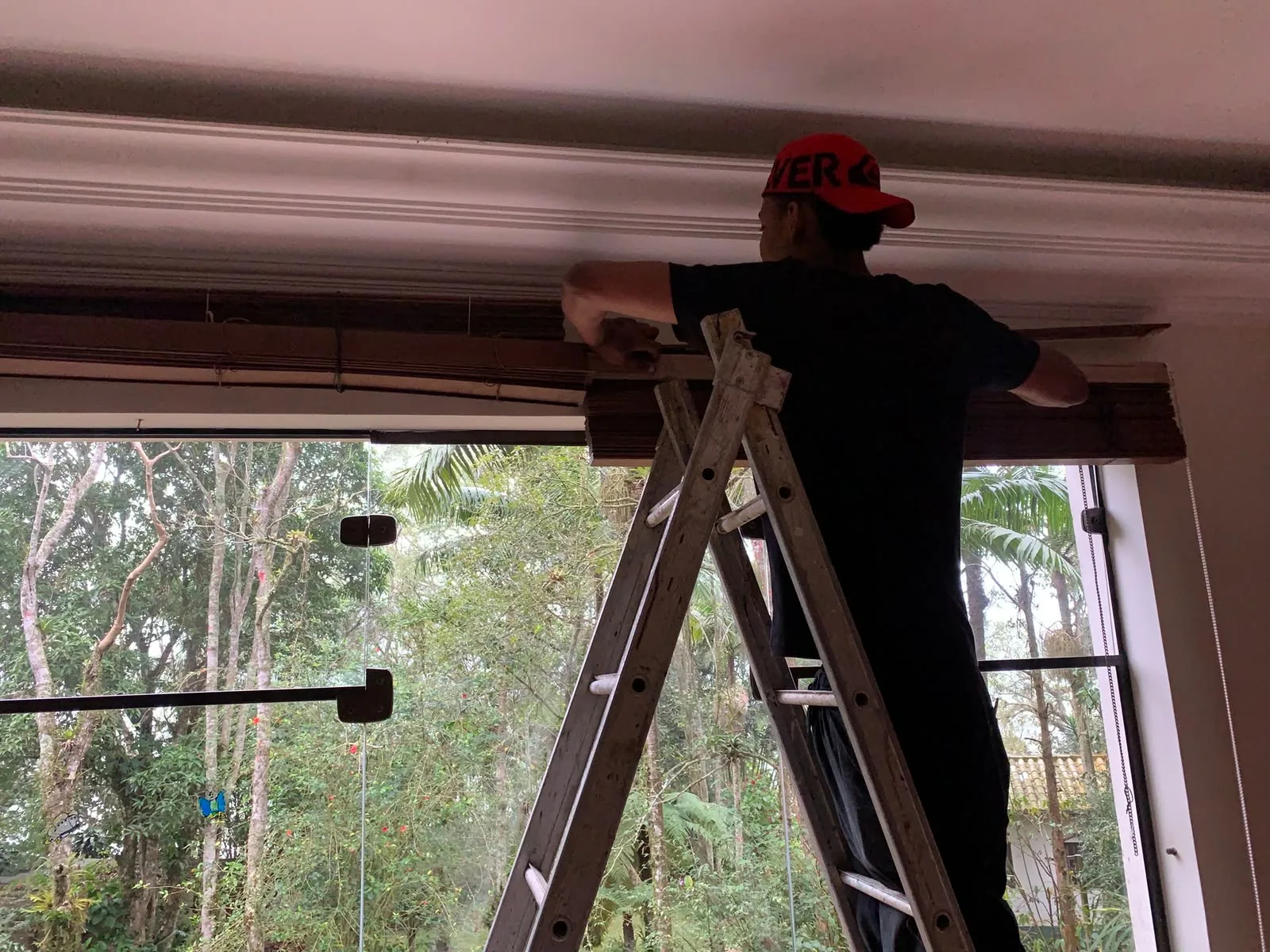 Técnico realizando manutenção de persiana